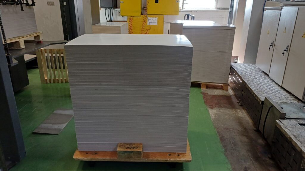 Stacks of printing paper in a climate-controlled room showing how substrate variability affects color consistency.