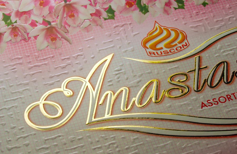 Close-up of premium carton packaging featuring gold hot foil stamping combined with intricate multi-level embossing.
