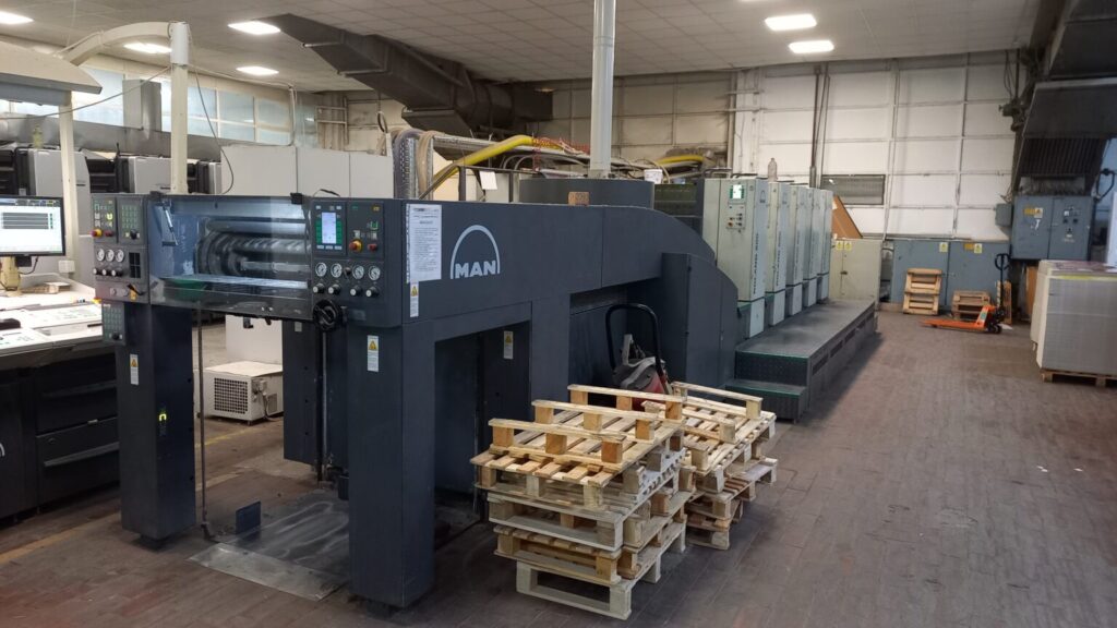 A multi-unit Manroland medium-format sheetfed offset printing press situated on a commercial print shop floor, prepared for high-volume production.